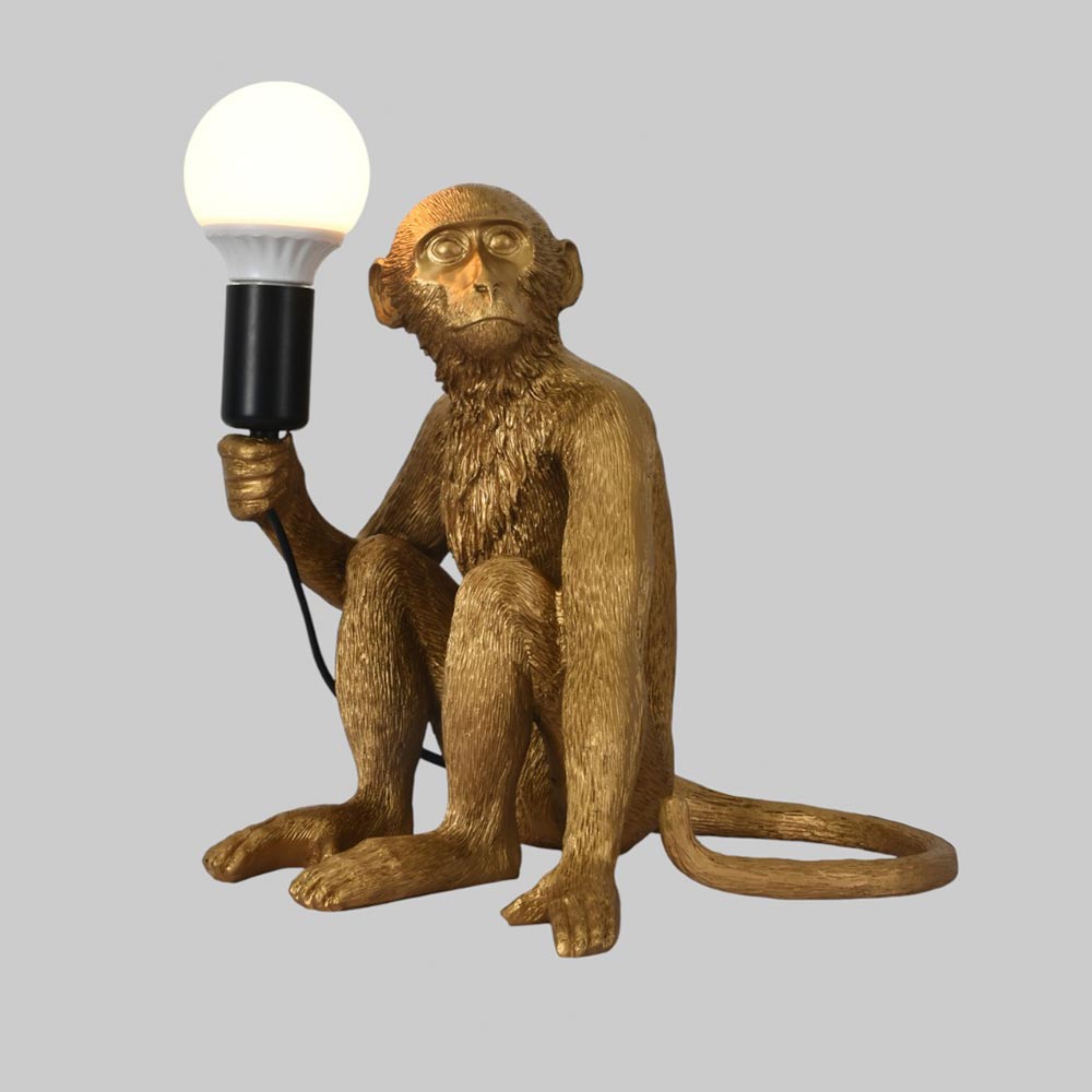 Lámpara de mesa E27 Mono sentado dorado